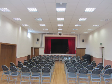 An image of a hall laid out with chairs for a stage performance