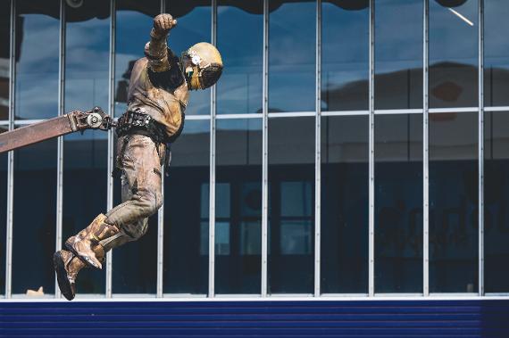 An astronaut hovers in the air in front of a glass window