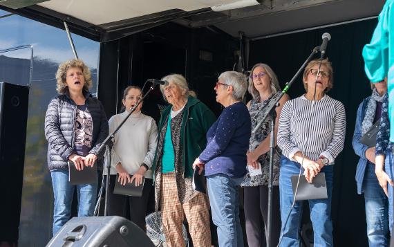 Preston People's Choir ladies singing in front of microphones