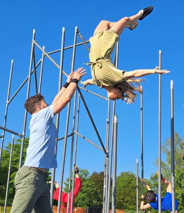 A WILD performer spins in the air as another performer catches her