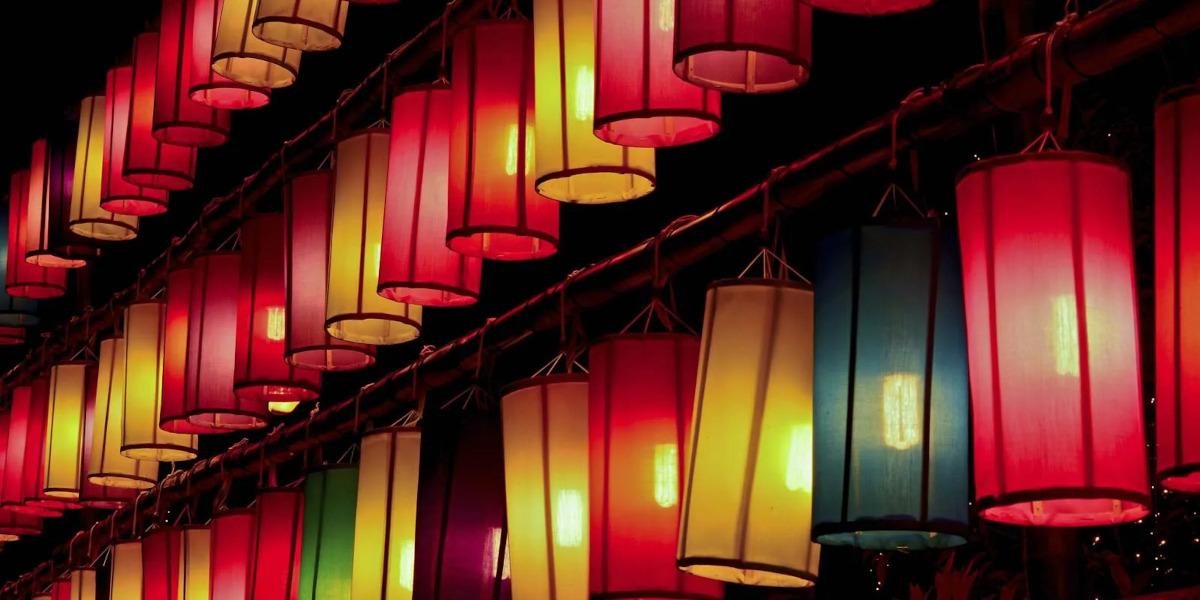 A line of lit up brightly coloured paper lanterns