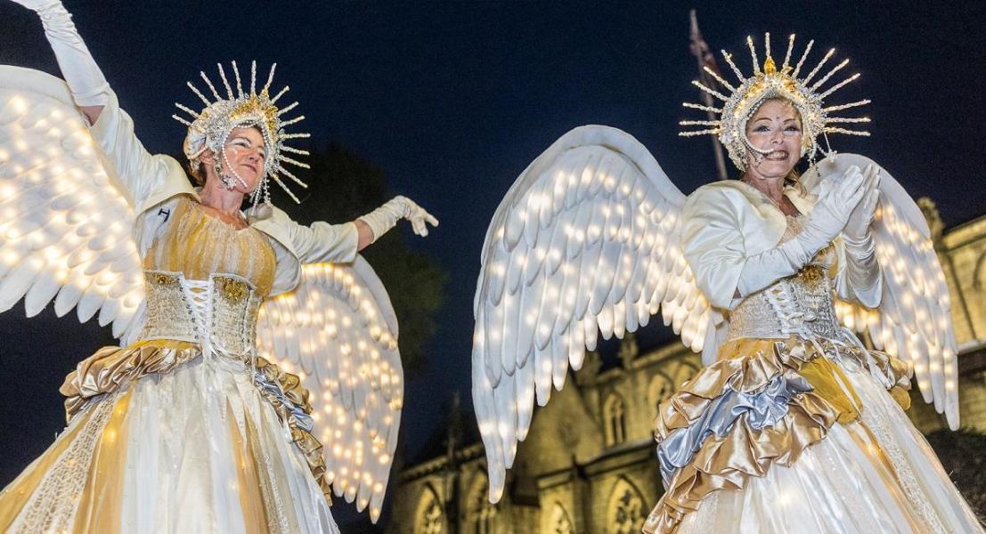 Women in illuminated angel costumes in Torchlight Procession