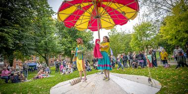 Hikapee Circus Theatre performing with a large beach umbrella in Winckley Square