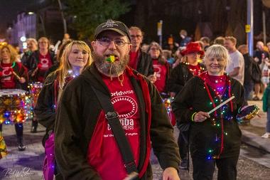 A man in the 2024 Encounter Festival procession with a whistle in his mouth.