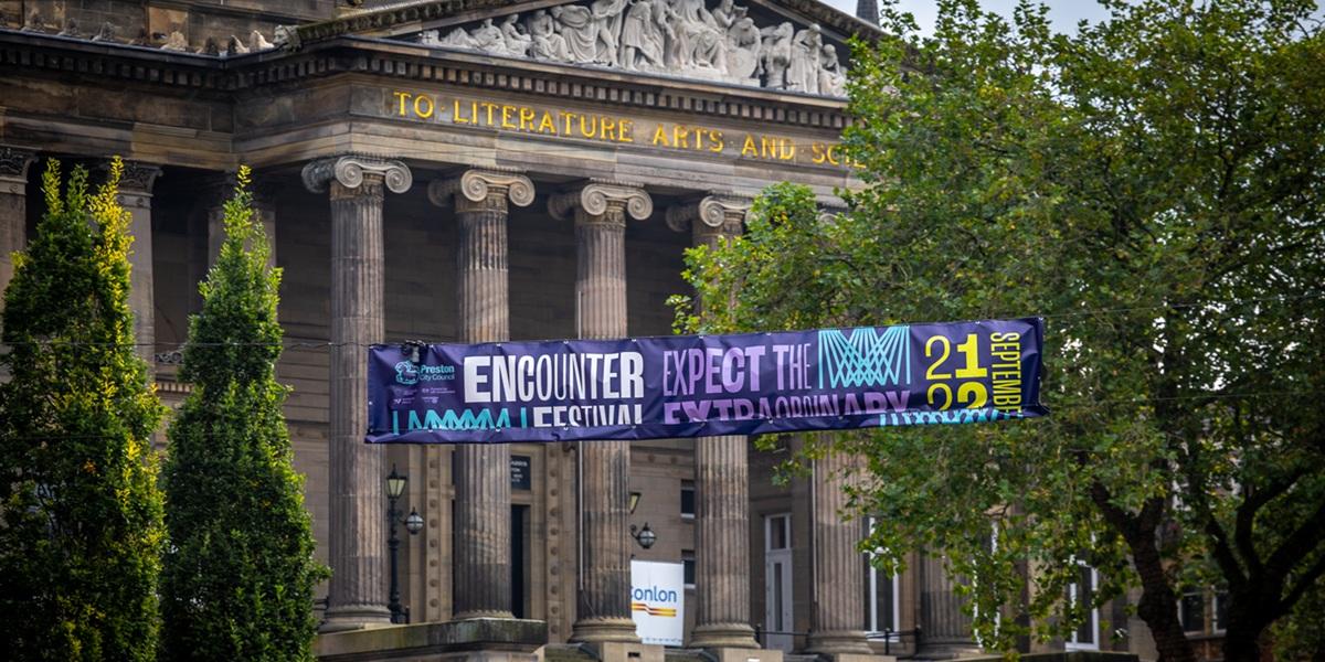 The Encounter Festival banner hanging with the Harris Museum in the background