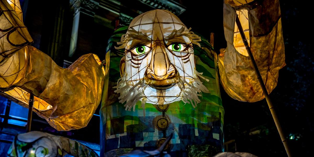 Main image: The light show giant 2017 Giant lantern in the shape of a giant man with a city on his back, from Brief Encounter 2017.