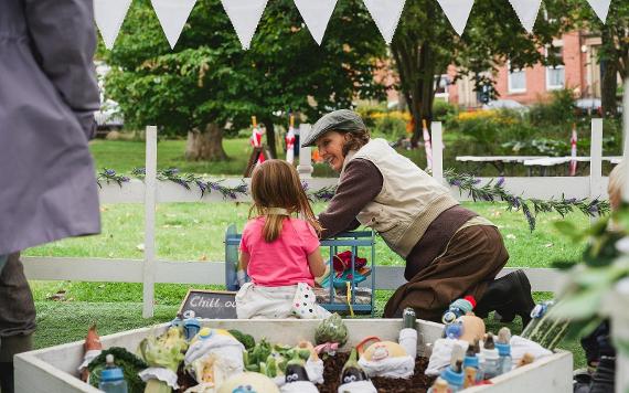 A lady and a little girl talking to vegetables